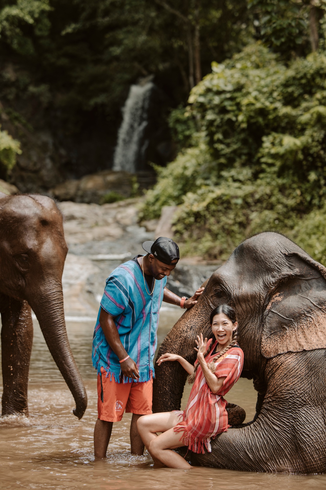 Stephanie and Quay meeting an elephant beside a waterfall