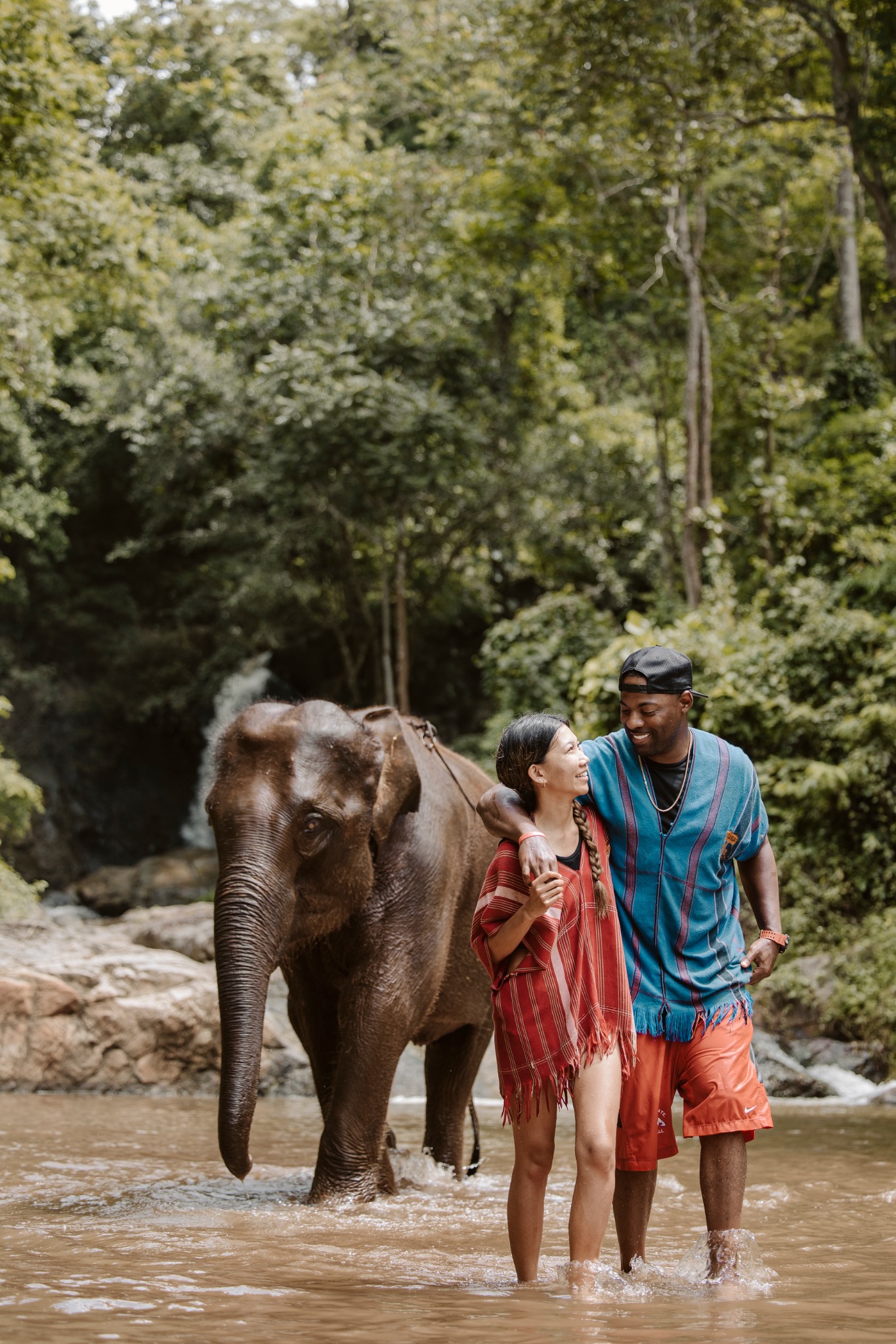 Stephanie and Quay walking beside an elephant