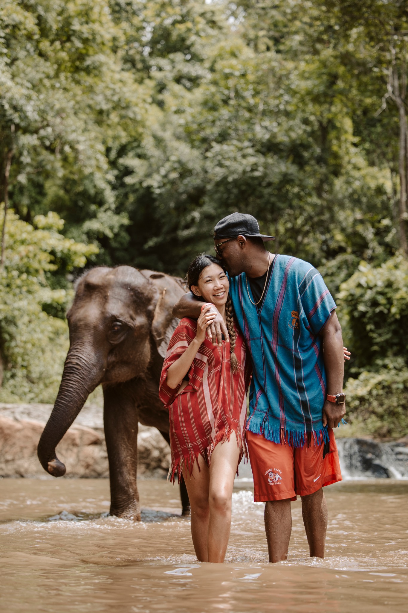 Stephanie and Quay smiling together beside an elephant