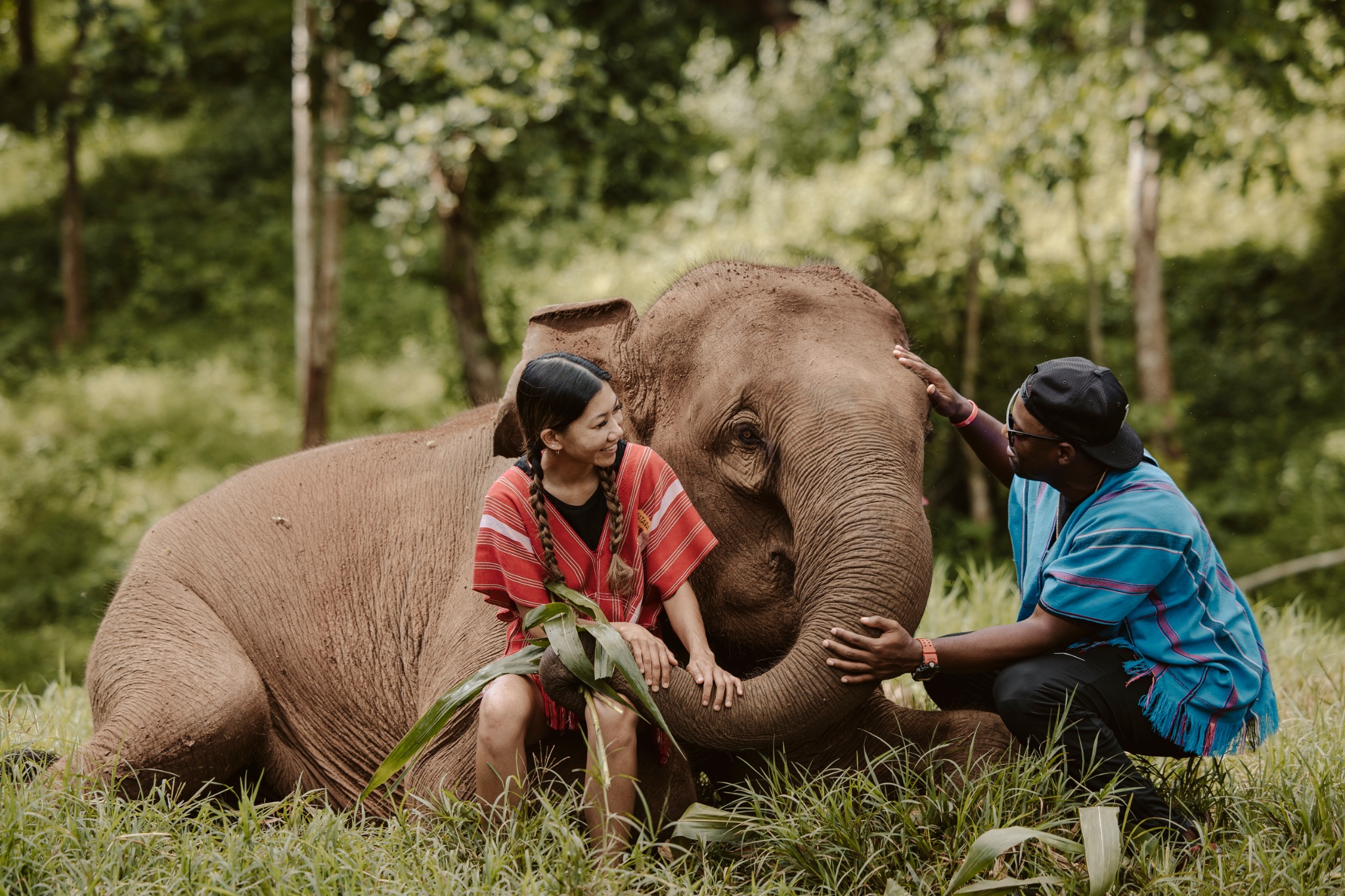 Stephanie and Quay sitting beside an elephant