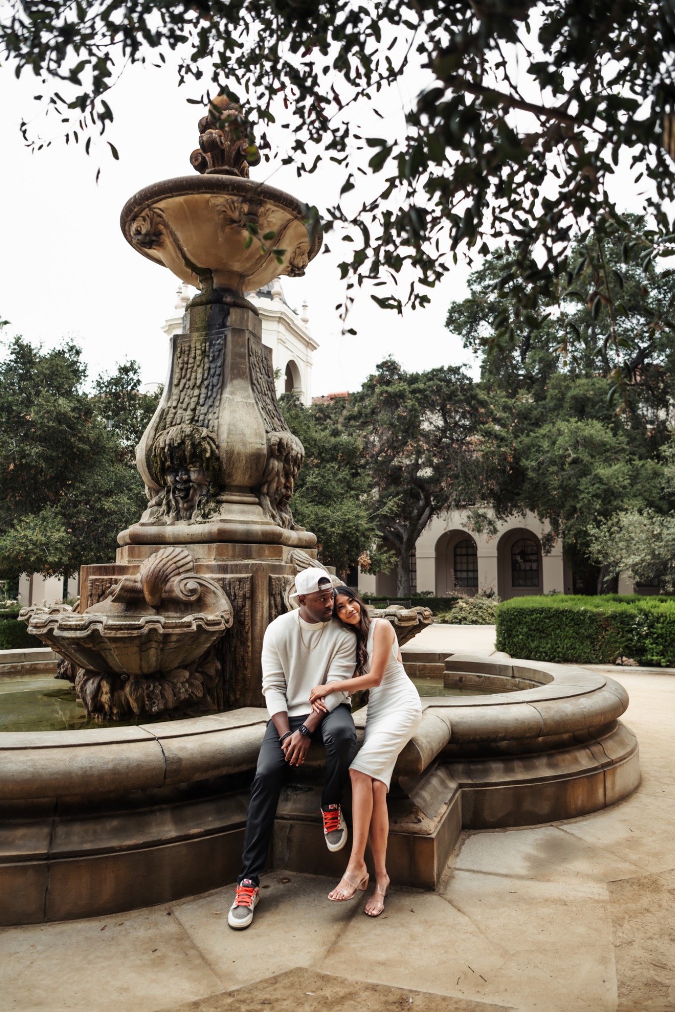 Stephanie and Quay sitting together beside a fountain