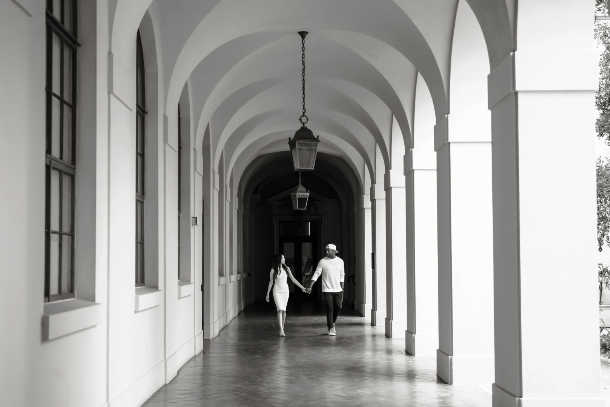 Black and white portrait beneath an arched walkway
